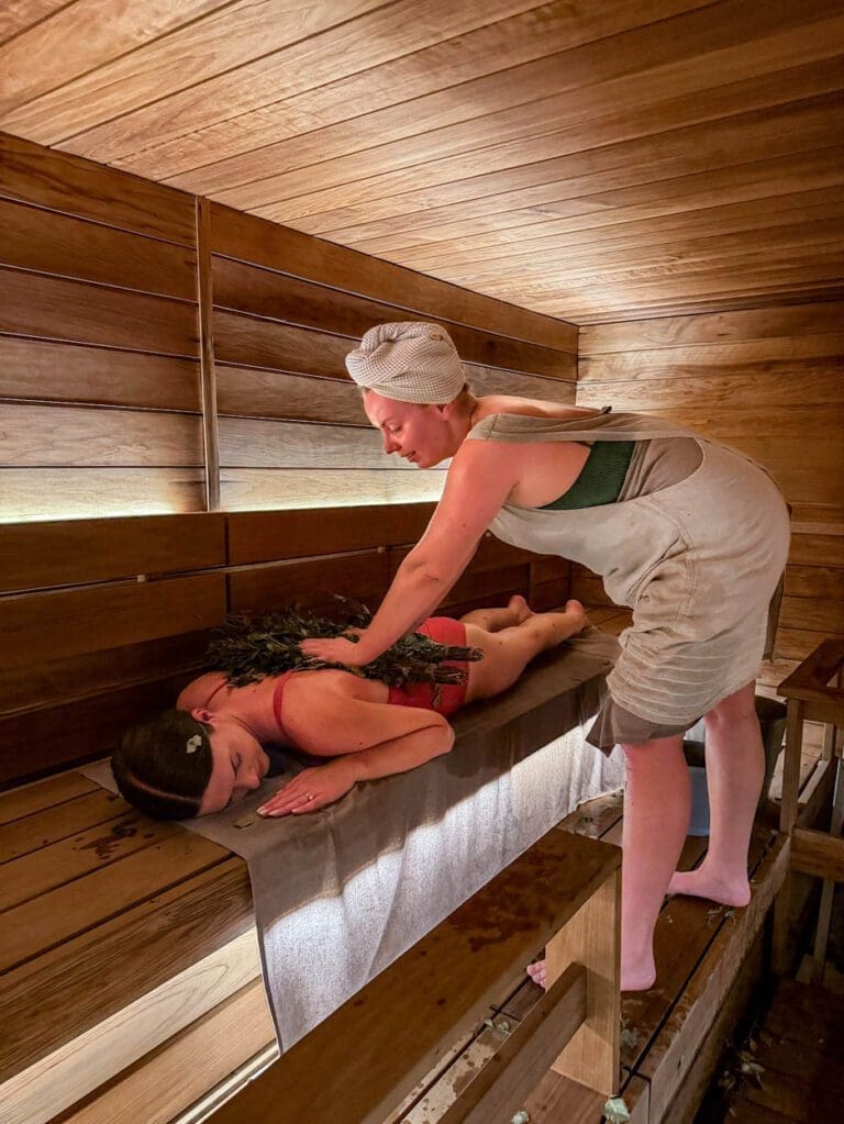 Woman doing whisking ritual at USVA Spa best things to do in Helsinki